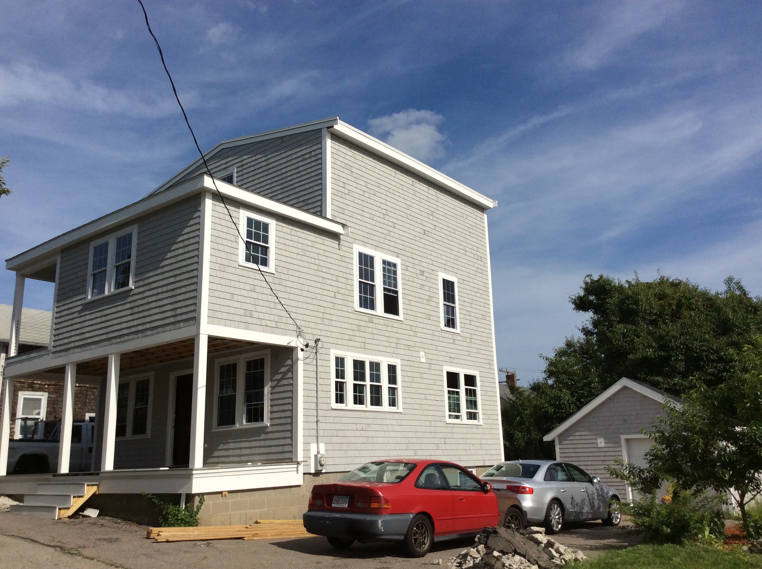 After photo — side view of the completed home expansion by Boston J's showing additional living space, new windows and exterior details