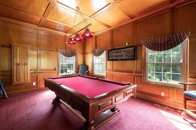 Custom wood-paneled billiard room by Boston J's featuring stained wall paneling, detailed trim work and a paneled ceiling