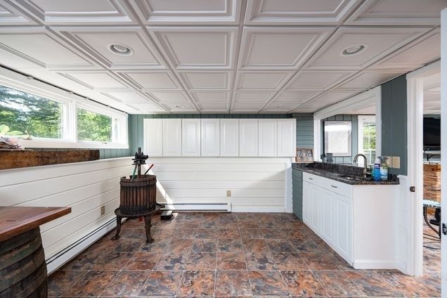 Custom coffered ceiling and fitted cabinetry completed by Boston J's featuring detailed ceiling grid, wall paneling and built-in storage
