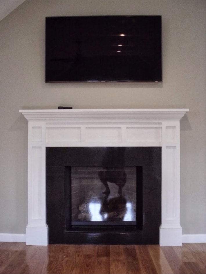 Custom built-in mantle with wall-mounted flat screen TV completed by Boston J's