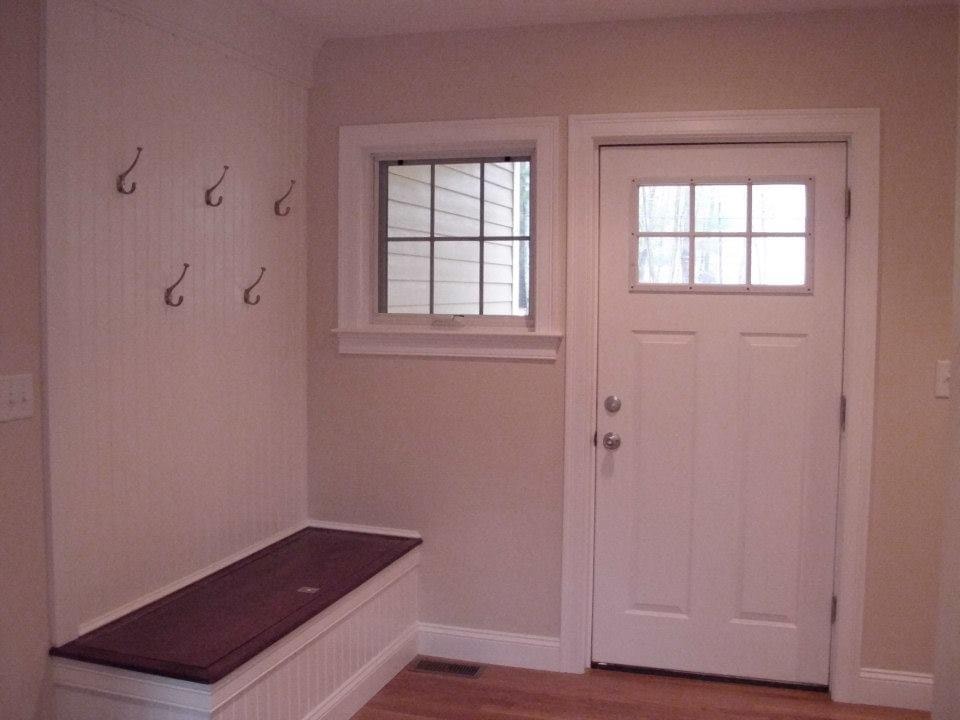 Custom built-in mudroom by Boston J's featuring individual storage bays, overhead cabinets, coat hooks and a dark wood bench